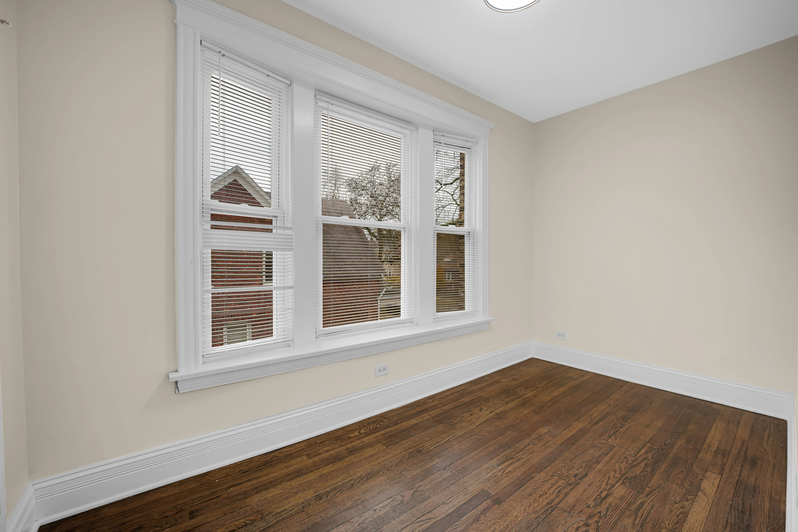 7621 South Normal Avenue Chicago, IL 60620 - Photo 21 of 32 a view of an empty room with wooden floor and a window