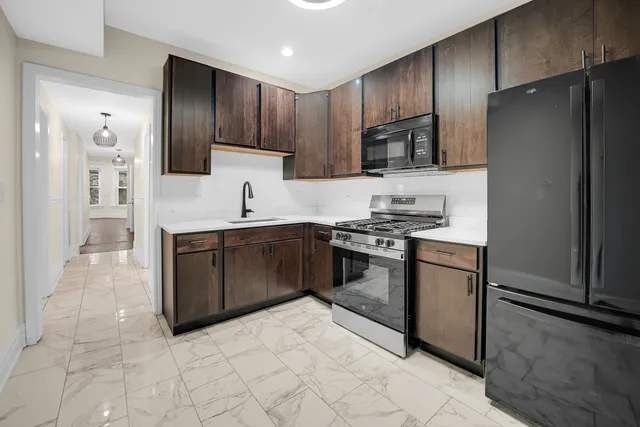 a kitchen with stainless steel appliances granite countertop a refrigerator stove top oven and sink