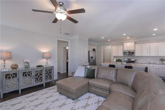 a living room with furniture a ceiling fan and a rug