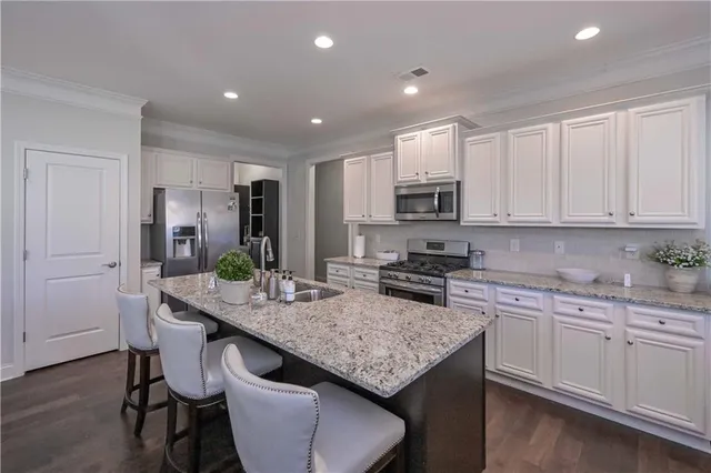 a kitchen with kitchen island granite countertop a sink and cabinets