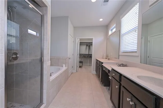 a spacious bathroom with a tub sink shower and mirror