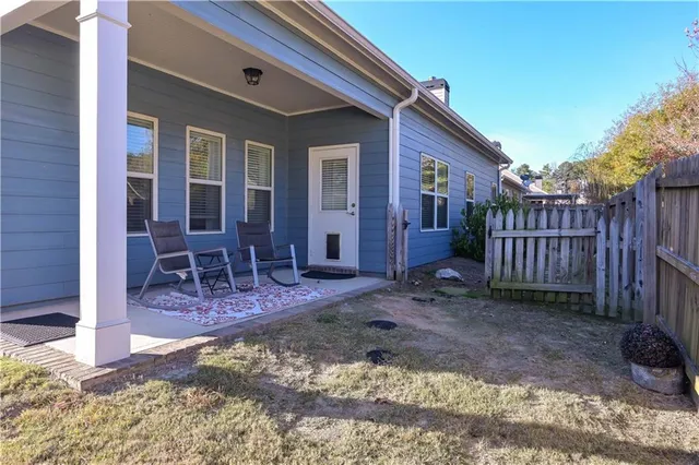 a view of house with backyard and chairs