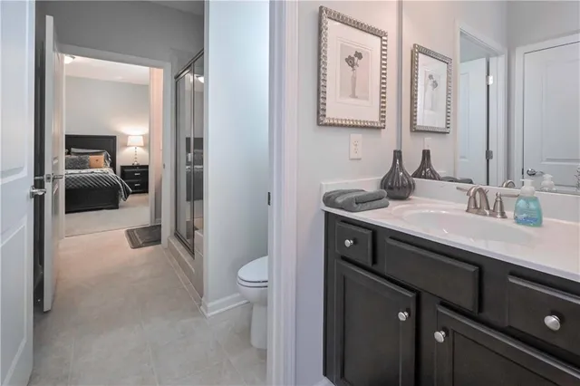 a en suite bathroom with a sink a toilet a mirror and shower