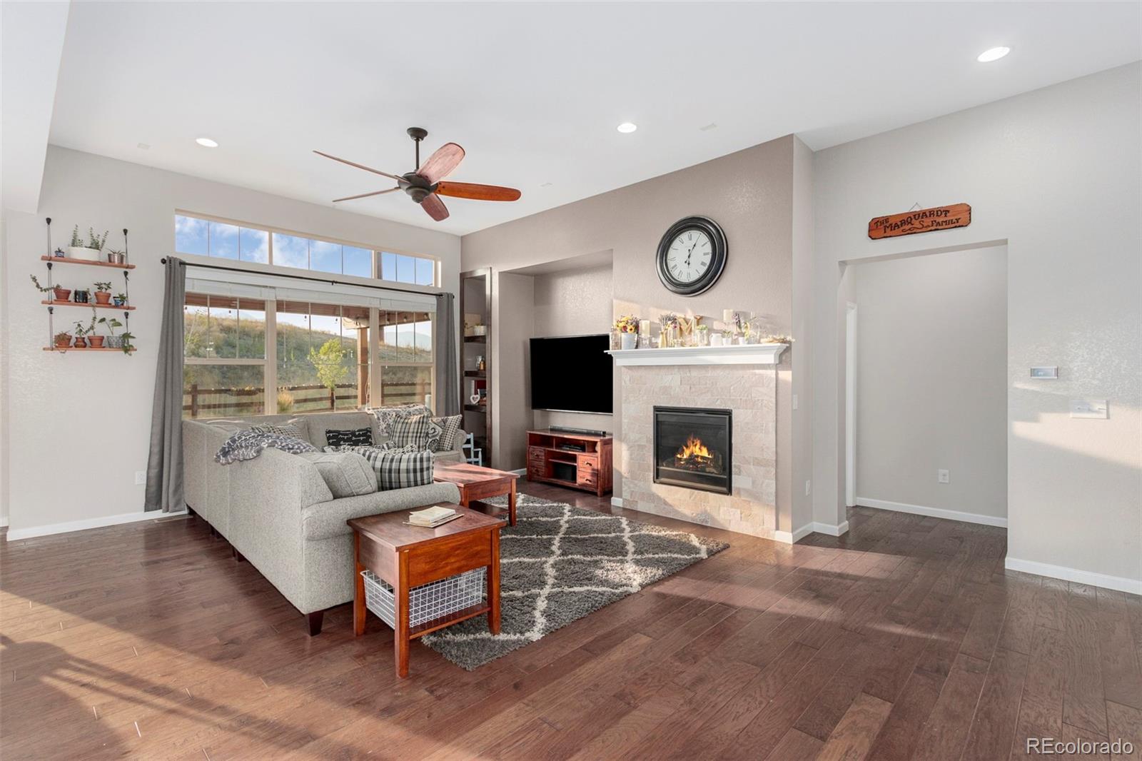 8875 Flattop Way Arvada, CO 80007 - Photo 12 of 38 a living room with furniture a fireplace and a flat screen tv