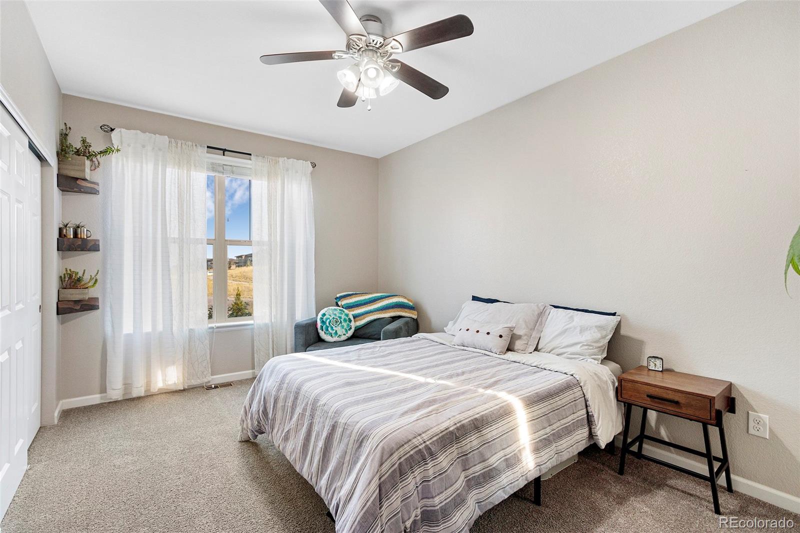 8875 Flattop Way Arvada, CO 80007 - Photo 14 of 38 a bedroom with a bed and a chandelier