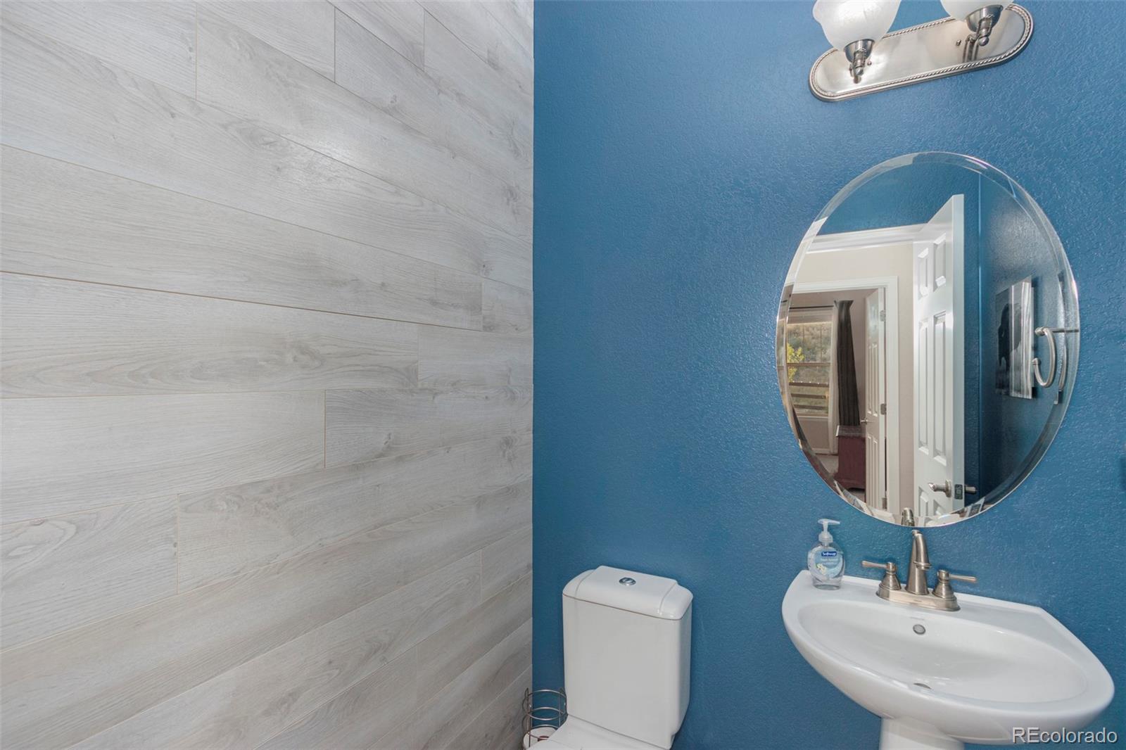 8875 Flattop Way Arvada, CO 80007 - Photo 16 of 38 a bathroom with a toilet sink and mirror
