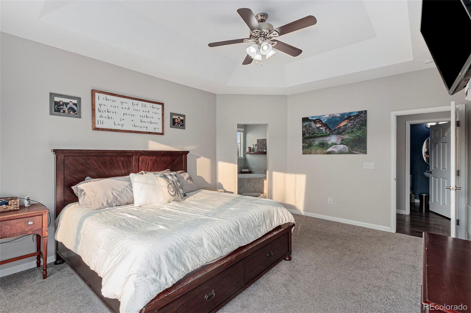 8875 Flattop Way Arvada, CO 80007 - Photo 18 of 38 a bedroom with a large bed and a chandelier