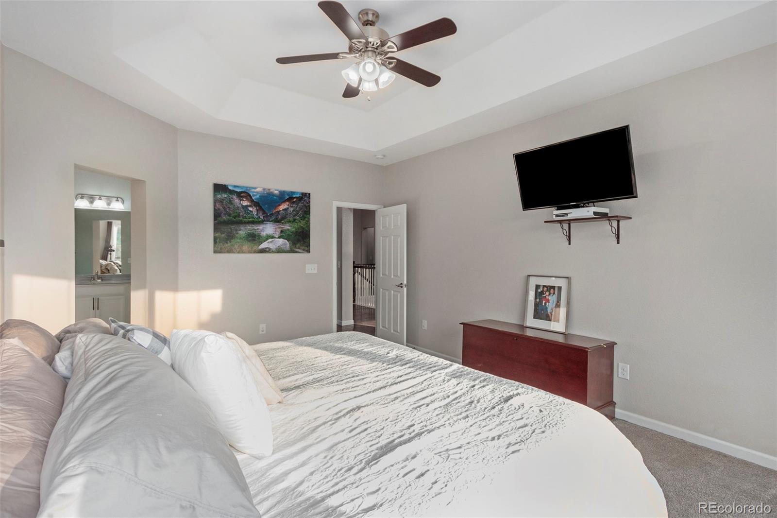 8875 Flattop Way Arvada, CO 80007 - Photo 19 of 38 a bedroom with a bed and a flat screen tv