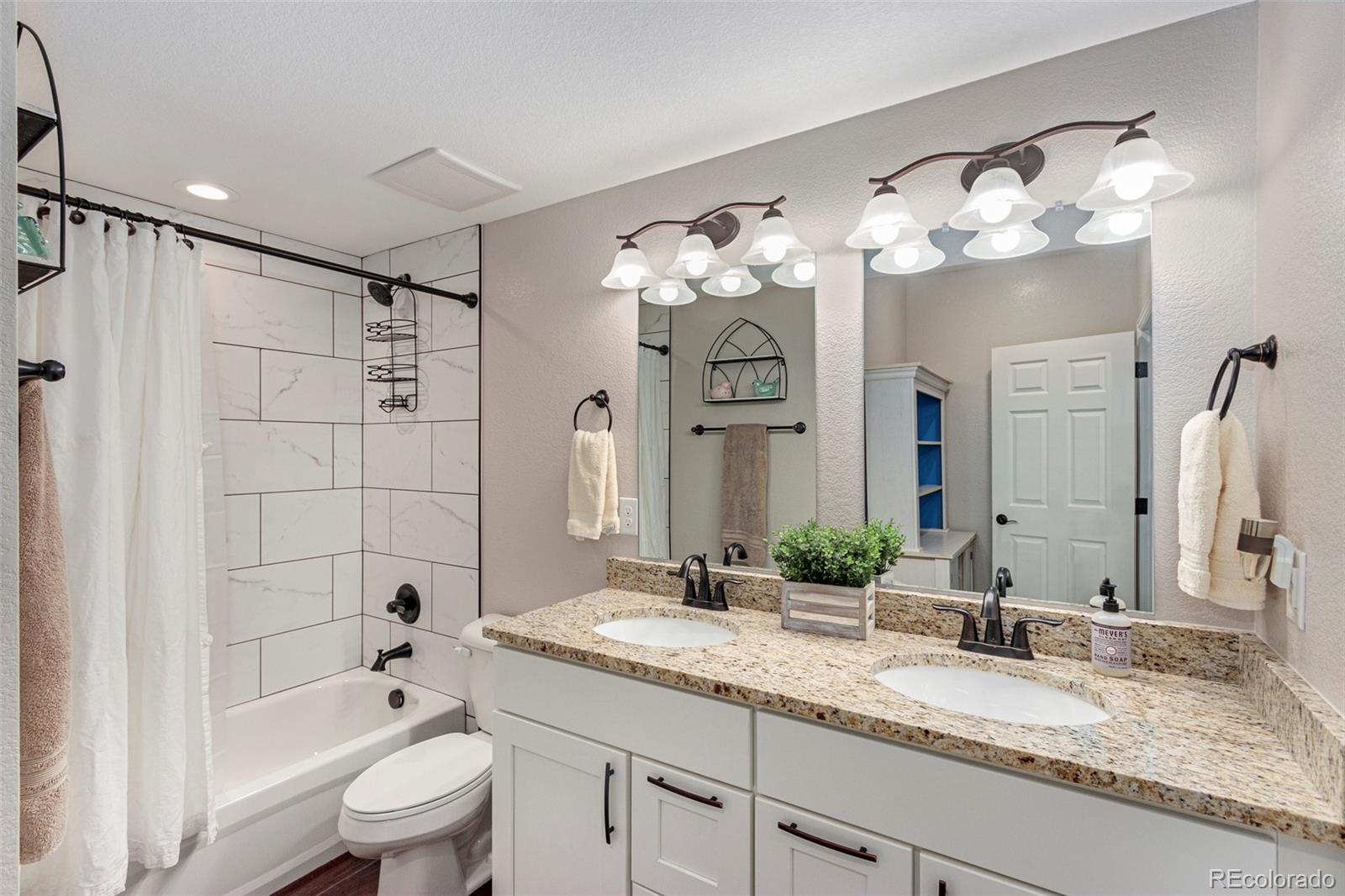 8875 Flattop Way Arvada, CO 80007 - Photo 26 of 38 a bathroom with a granite countertop sink a toilet and shower