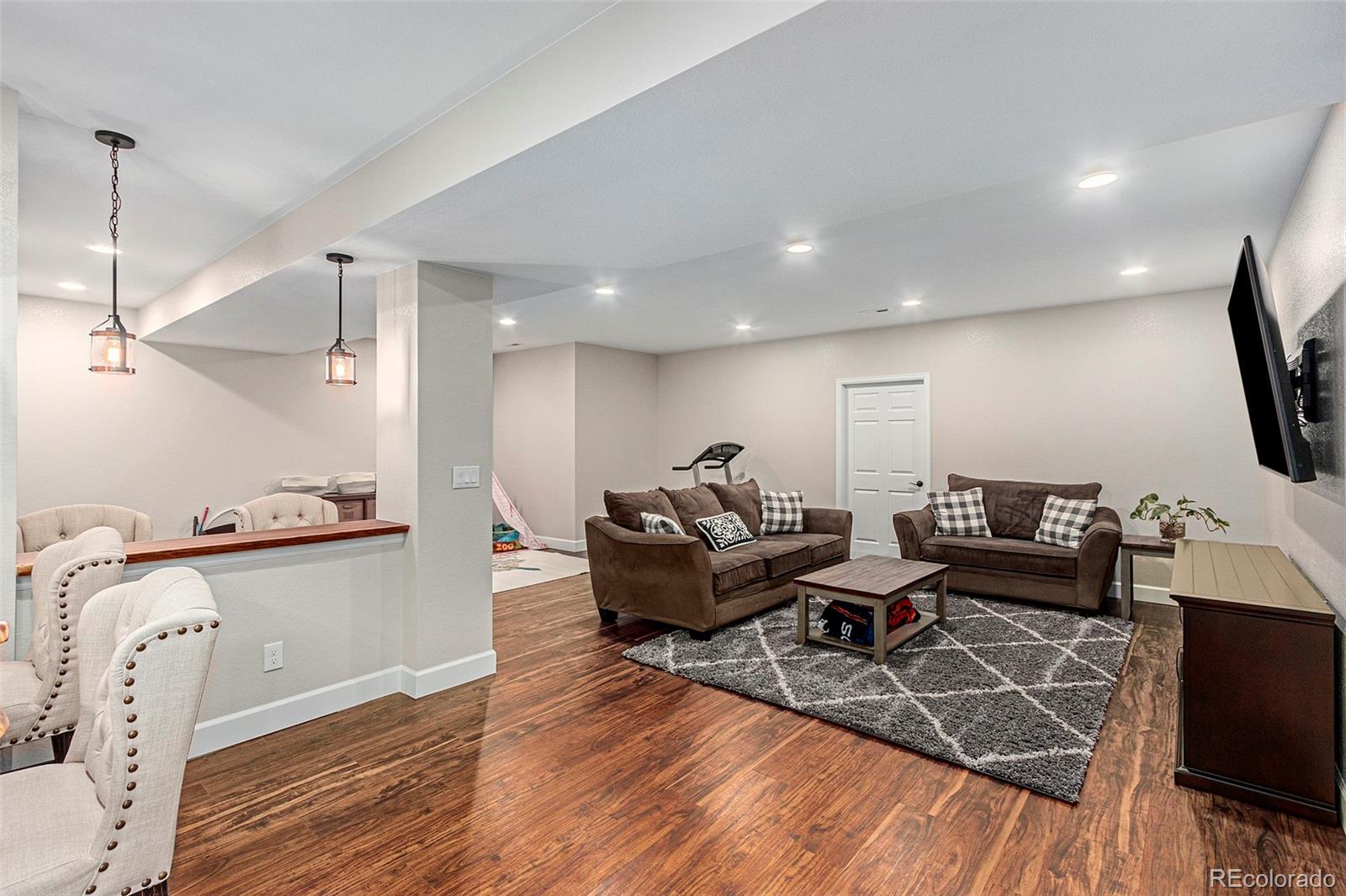 8875 Flattop Way Arvada, CO 80007 - Photo 30 of 38 a living room with furniture and a flat screen tv