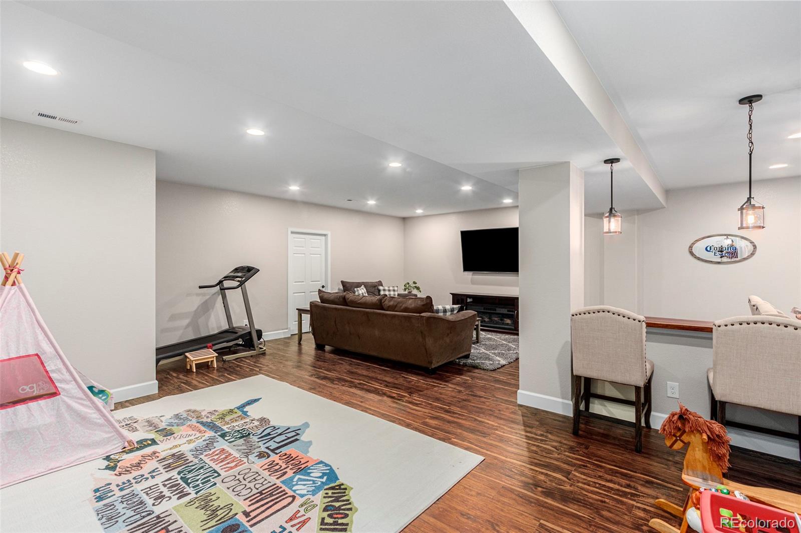 8875 Flattop Way Arvada, CO 80007 - Photo 32 of 38 a living room with furniture and a flat screen tv