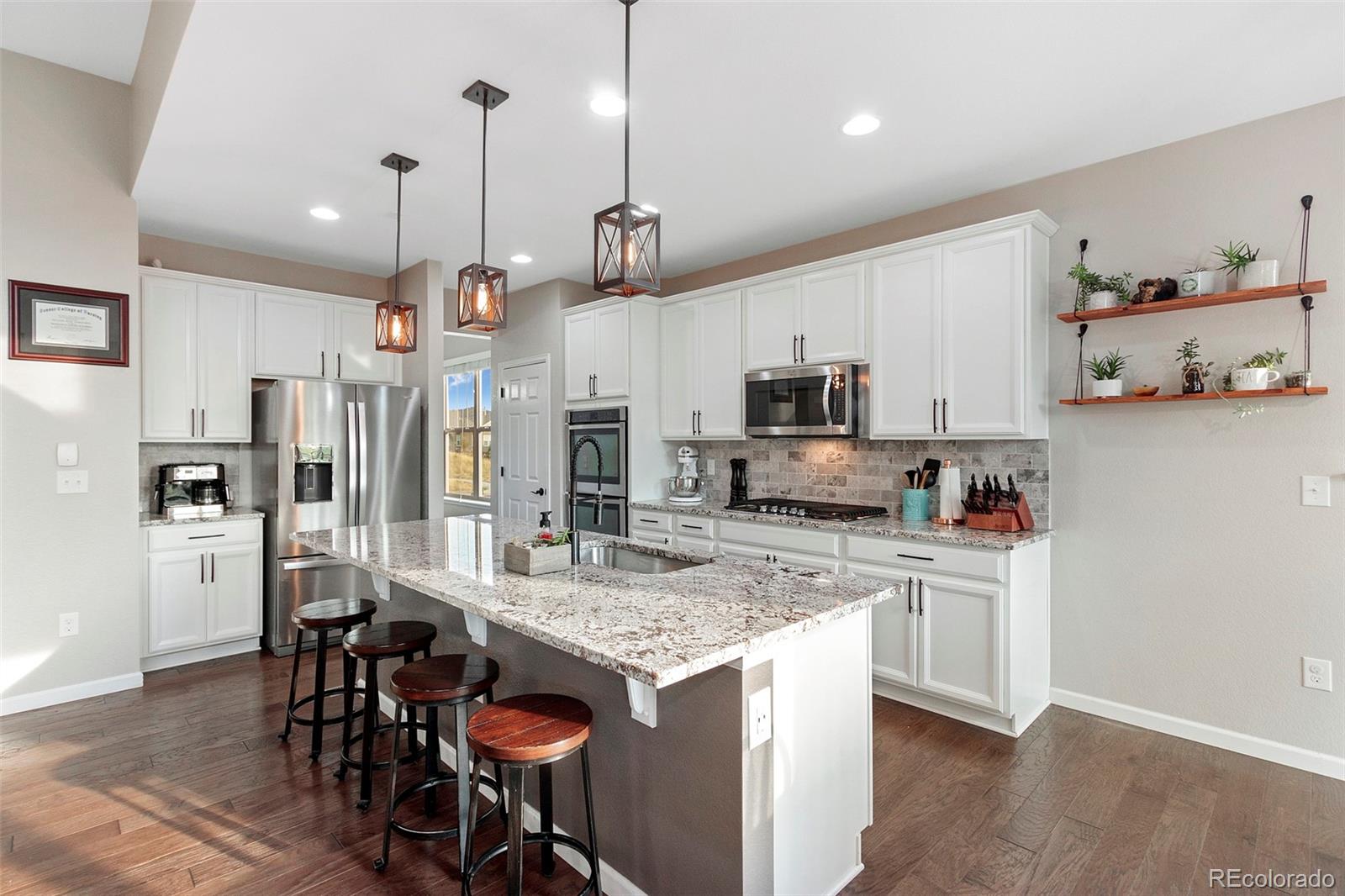 8875 Flattop Way Arvada, CO 80007 - Photo 6 of 38 a kitchen with kitchen island granite countertop a sink a center island and stainless steel appliances