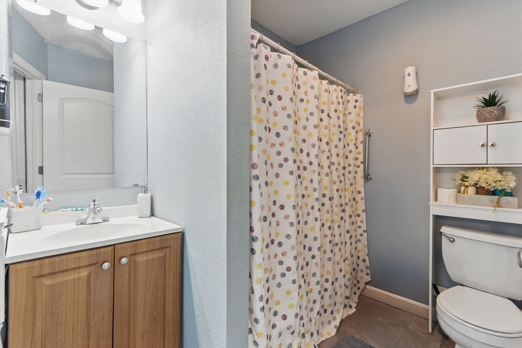 166-168 Corthell Street Springfield, MA 01151 - Photo 11 of 33 a bathroom with a sink a toilet and shower curtain