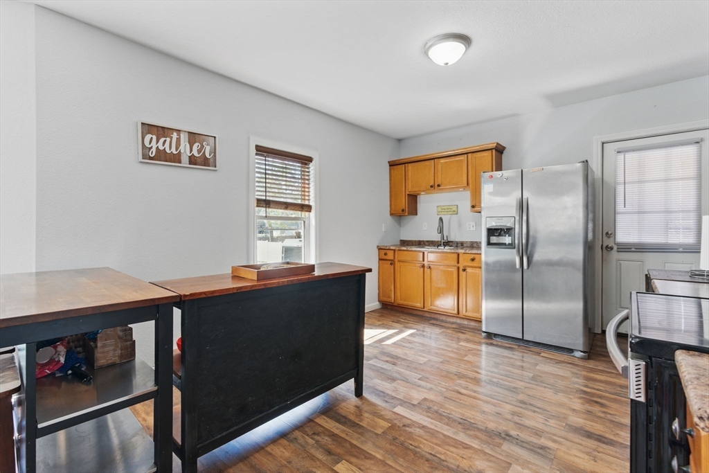 166-168 Corthell Street Springfield, MA 01151 - Photo 21 of 33 a kitchen with granite countertop a refrigerator cabinets and wooden floor