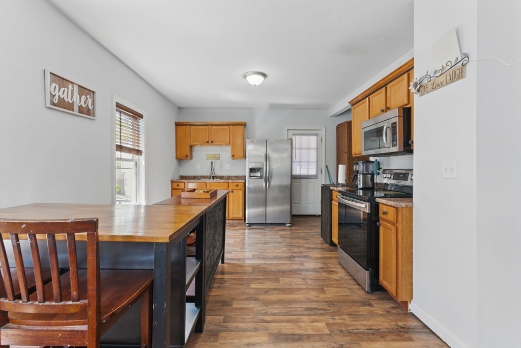 166-168 Corthell Street Springfield, MA 01151 - Photo 22 of 33 a kitchen with stainless steel appliances granite countertop a refrigerator a stove a sink dishwasher and wooden cabinets with wooden floor