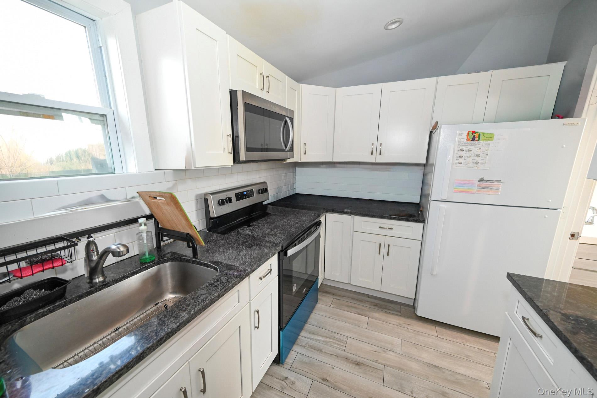 45 Rider Avenue Patchogue, NY 11772 - Photo 13 of 29 a kitchen with granite countertop a sink stove and refrigerator