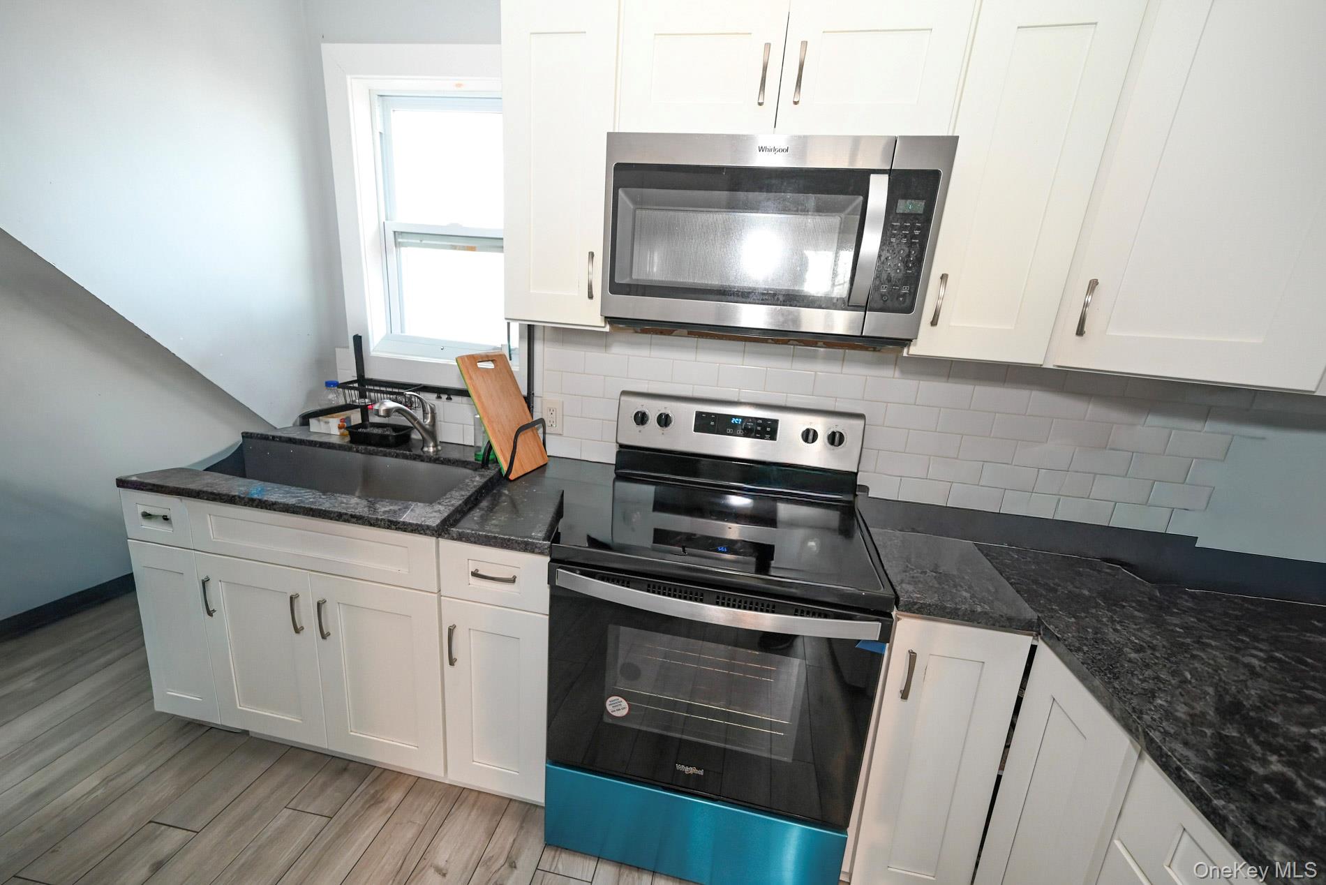 45 Rider Avenue Patchogue, NY 11772 - Photo 14 of 29 a kitchen with granite countertop a stove and a microwave