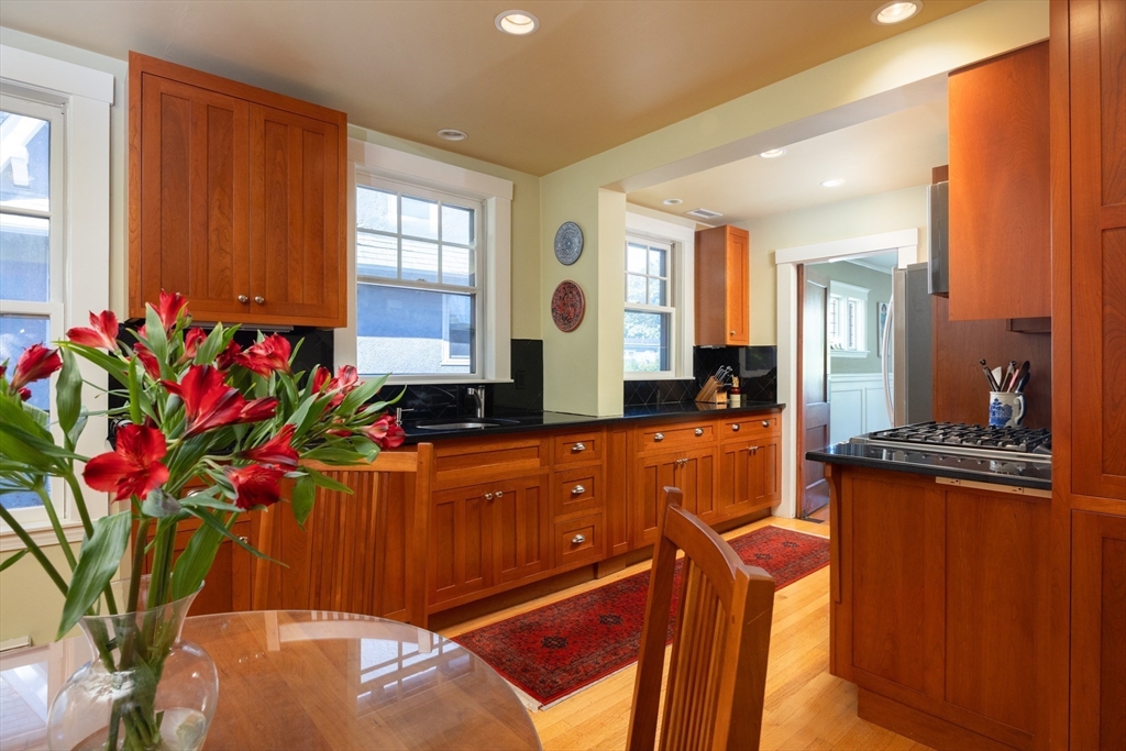 139 University Road, Unit 2 Brookline, MA 02445 - Photo 7 of 16 a living room with large windows and flower plants