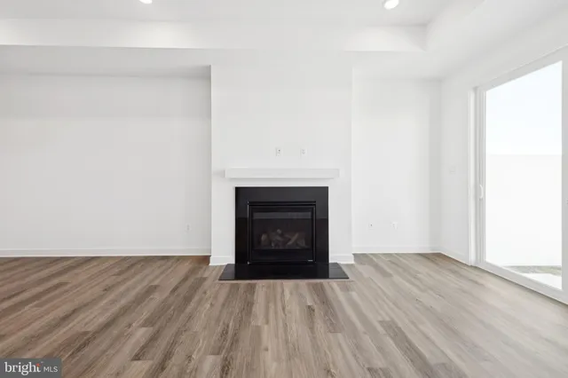 a view of empty room with wooden floor and fireplace