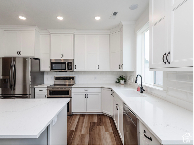 374 Ropelato Drive Nibley, UT 84321 - Photo 3 of 15 Kitchen featuring stainless steel appliances, plenty of natural light, white cabinets, light wood-style flooring, and recessed lighting
