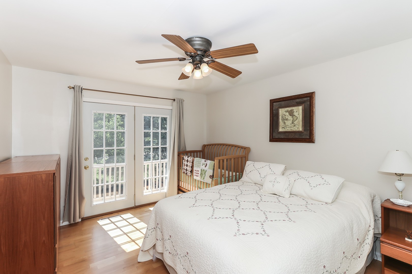 207 Ela Road Inverness, IL 60067 - Photo 23 of 30 a bedroom with a large bed and a chandelier