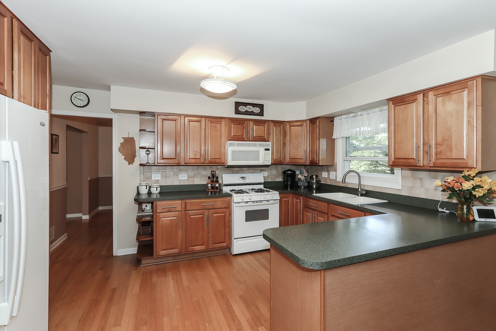 207 Ela Road Inverness, IL 60067 - Photo 6 of 30 a kitchen with stainless steel appliances granite countertop a refrigerator a sink dishwasher a stove and white countertops with wooden floor