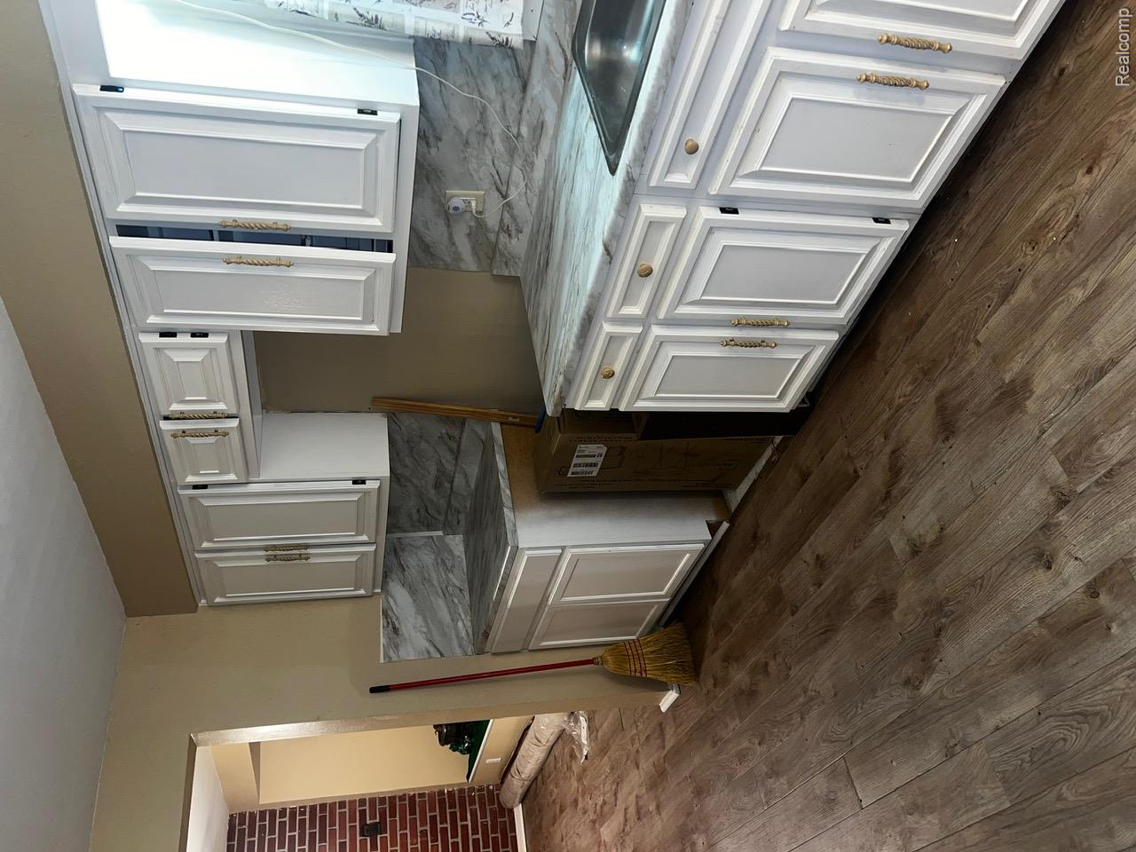 3364 East Pierson Road Flint, MI 48506 - Photo 14 of 67 Kitchen featuring tasteful backsplash, dark wood-style floors, white cabinetry, and light stone counters