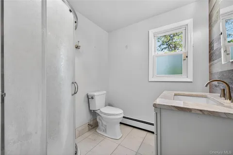 a bathroom with a granite countertop toilet sink and mirror