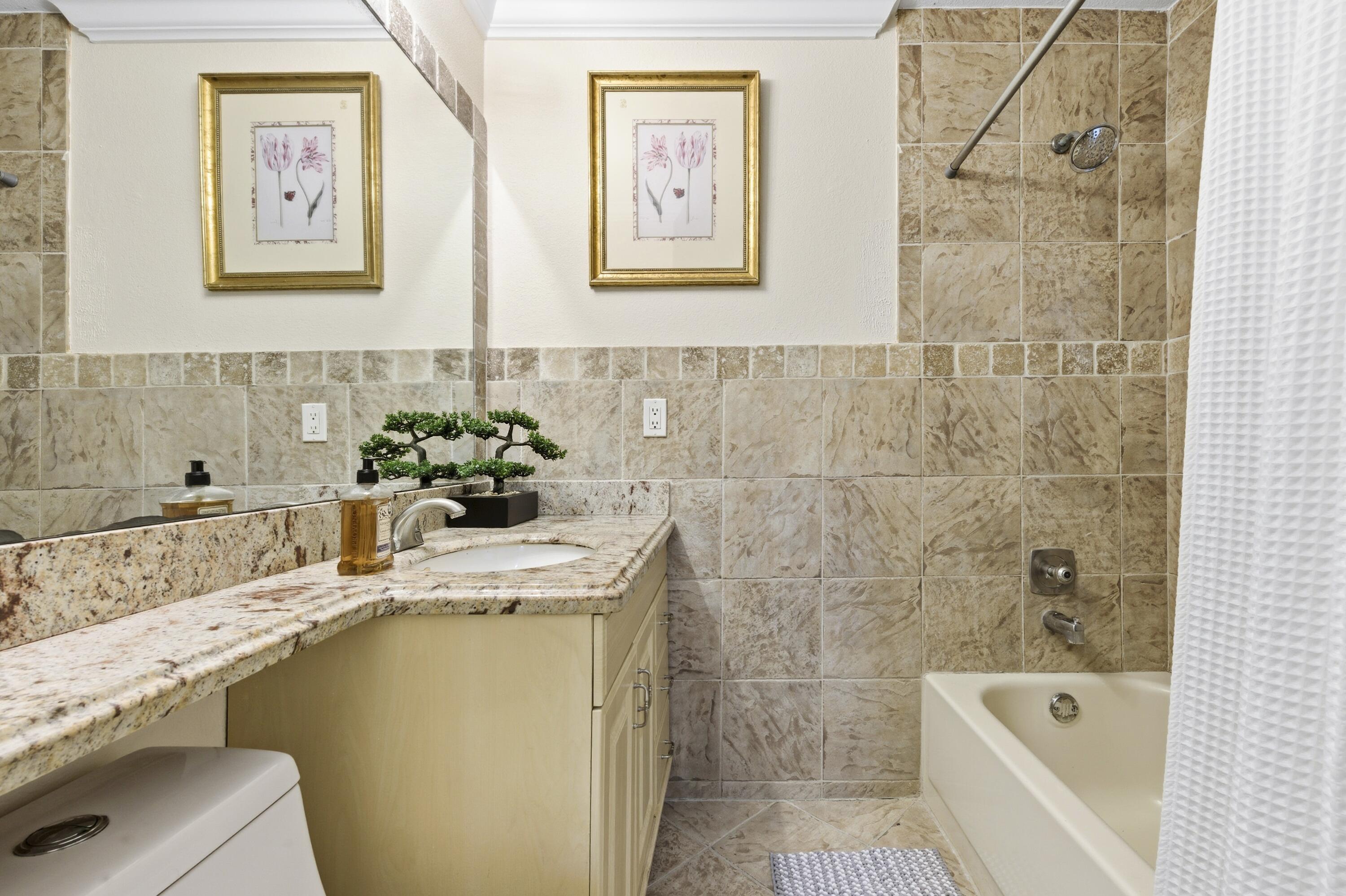 1945 Northwest 4th Avenue, Unit 43C Boca Raton, FL 33432 - Photo 22 of 23 a bathroom with a tub sink and mirror