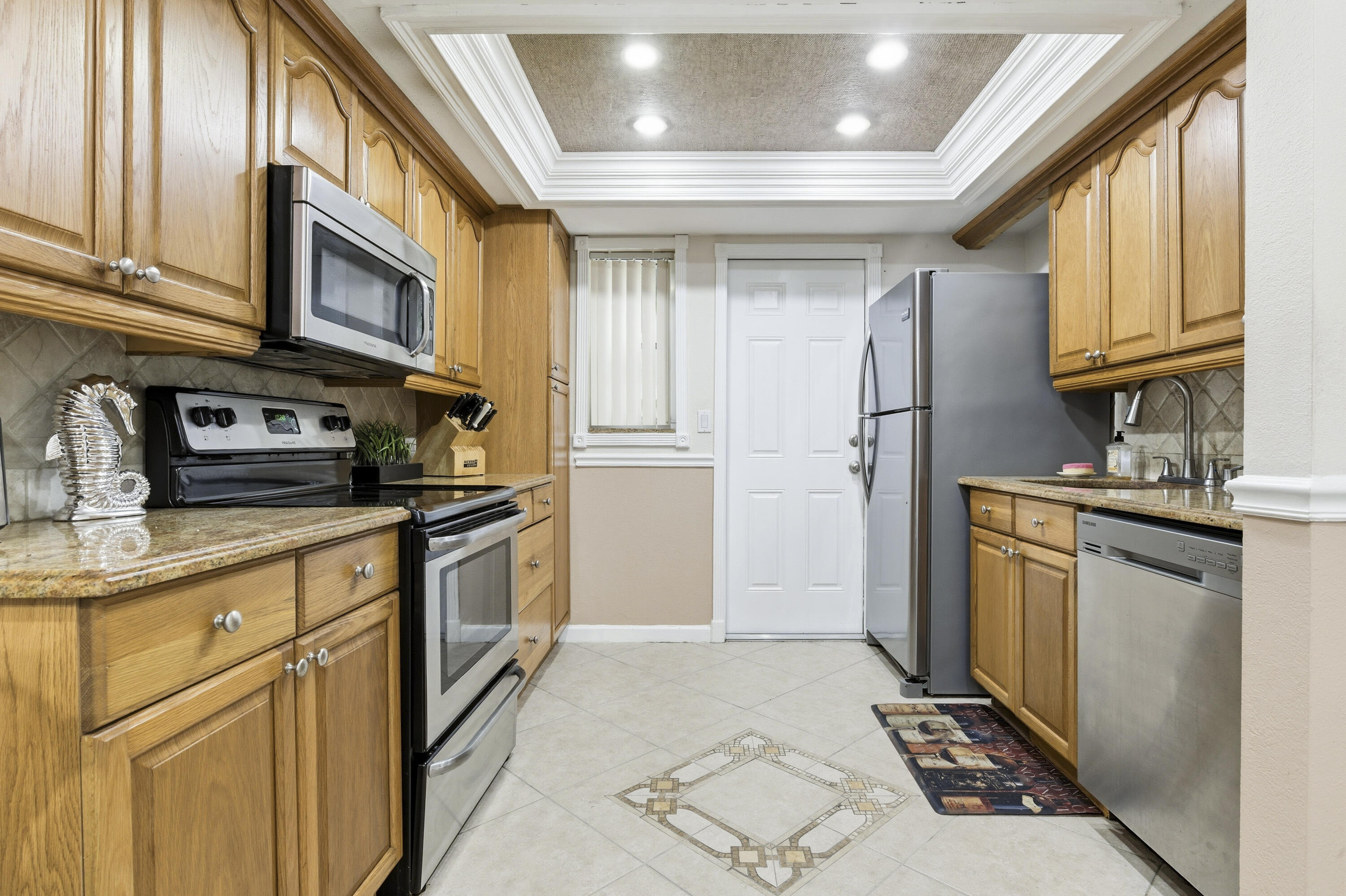 1945 Northwest 4th Avenue, Unit 43C Boca Raton, FL 33432 - Photo 9 of 23 a kitchen with stainless steel appliances granite countertop a refrigerator a stove and a sink with dishwasher