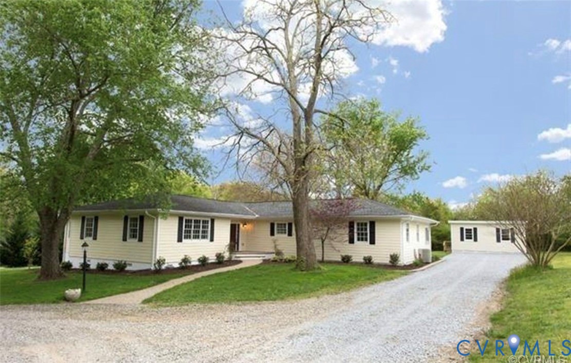 a front view of a house with a garden and trees