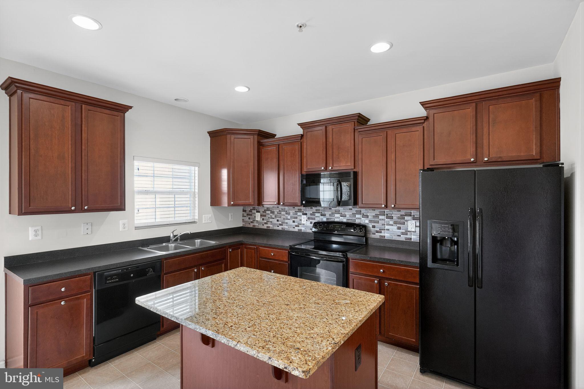 11831 Sunset Ridge Place Waldorf, MD 20602 - Photo 4 of 24 a kitchen with stainless steel appliances granite countertop a refrigerator a sink a stove a kitchen island and cabinets