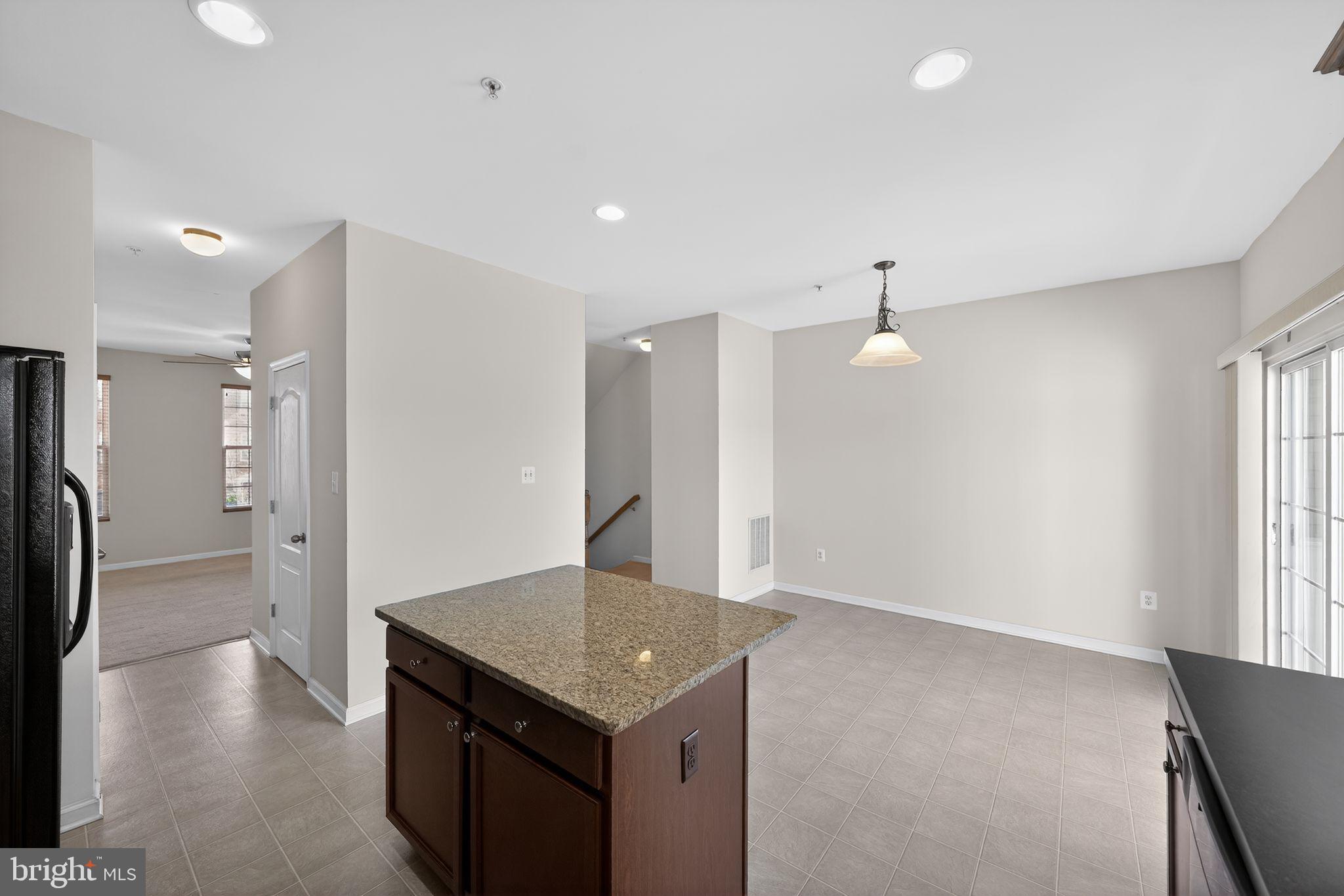 11831 Sunset Ridge Place Waldorf, MD 20602 - Photo 6 of 24 a kitchen with kitchen island a refrigerator stove and a sink