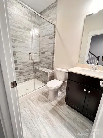 a bathroom with a sink a toilet a mirror and shower