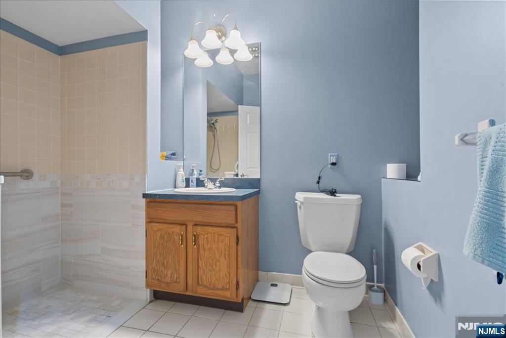 2 Richmond Road, Unit 306 West Milford, NJ 07480 - Photo 11 of 33 a bathroom with a toilet a sink and mirror