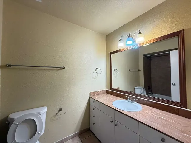 a bathroom with a granite countertop toilet sink and shower