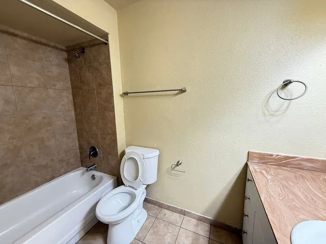 an empty room with wooden floor and fan