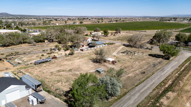 1211 West Midvalley Road Cedar City, UT 84721 - Photo 3 of 14 Expansive rural property featuring an unpaved road, mature trees, and a distant field