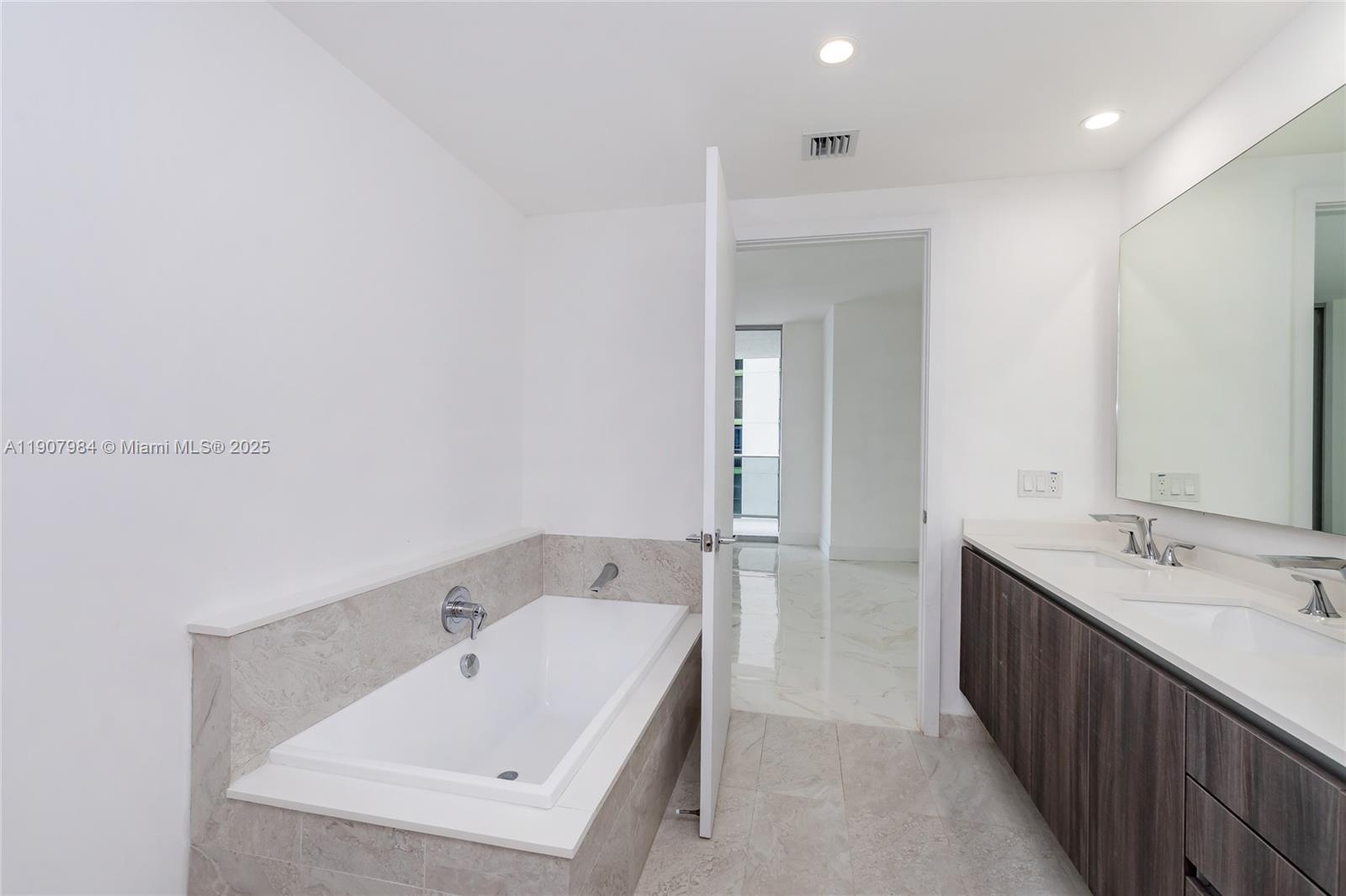 488 Northeast 18th Street, Unit 2810 Miami, FL 33132 - Photo 20 of 31 a bathroom with a tub sink and mirror