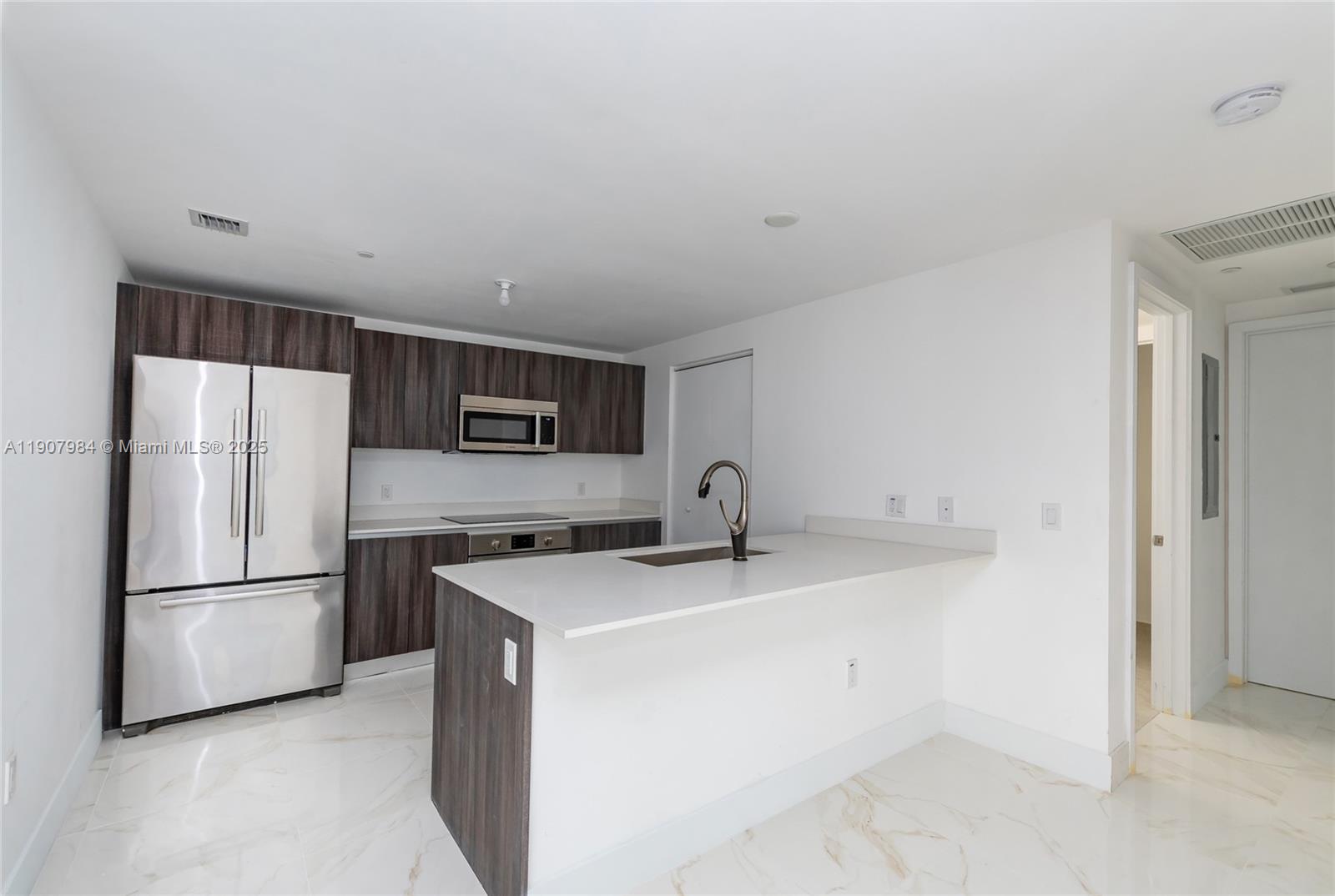 488 Northeast 18th Street, Unit 2810 Miami, FL 33132 - Photo 6 of 31 a kitchen with stainless steel appliances granite countertop a refrigerator a sink a stove a microwave and white cabinets