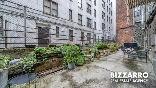 a view of a patio with plants and chairs
