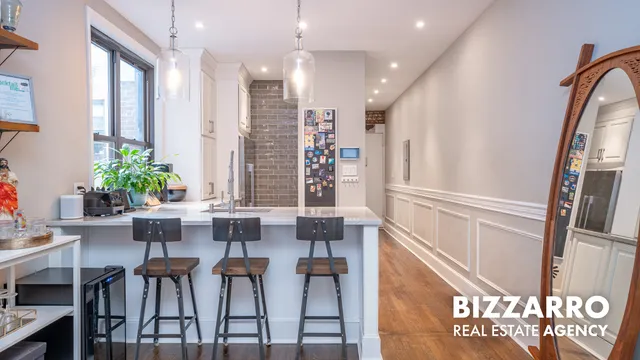 a view of a hallway with furniture and wooden floor