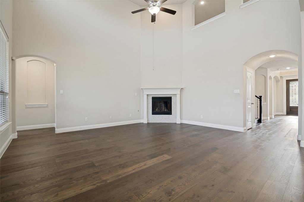 2802 Merlot Circle Rowlett, TX 75088 - Photo 9 of 40 an empty room with wooden floor a ceiling fan and kitchen view