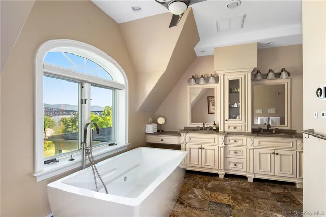 a spacious bathroom with a granite countertop tub sink and mirror