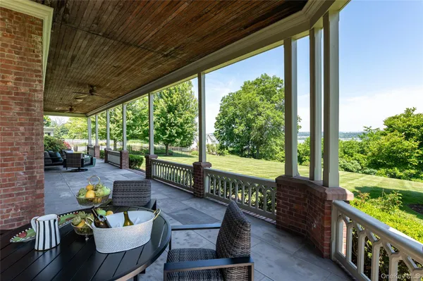 a view of a patio with couches chairs and wooden floor