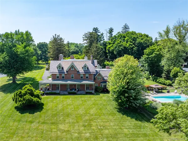a aerial view of a house with a big yard and large trees