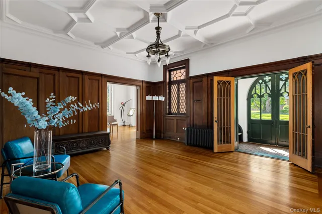 a living room with furniture potted plant floor to ceiling window and a flat screen tv