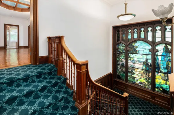 a view of staircase with railing and a window