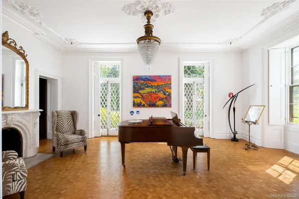 a living room with furniture a fireplace and a chandelier
