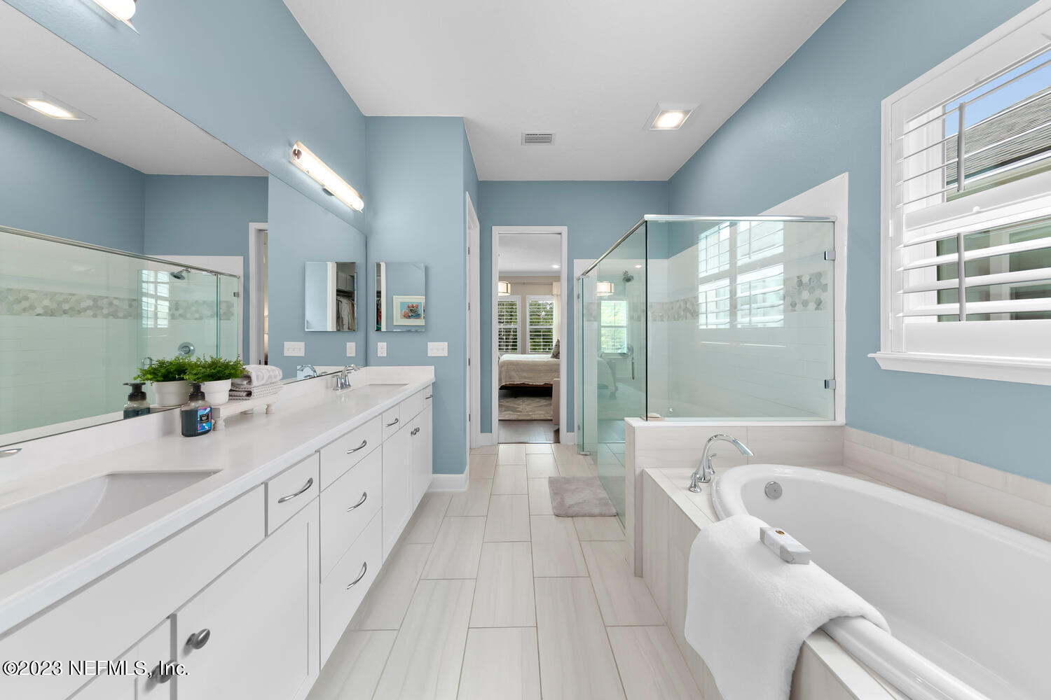 110 Pine Manor Drive Jacksonville, FL 32081 - Photo 22 of 55 a spacious en suite bathroom with a granite countertop tub and a large mirror next to a window